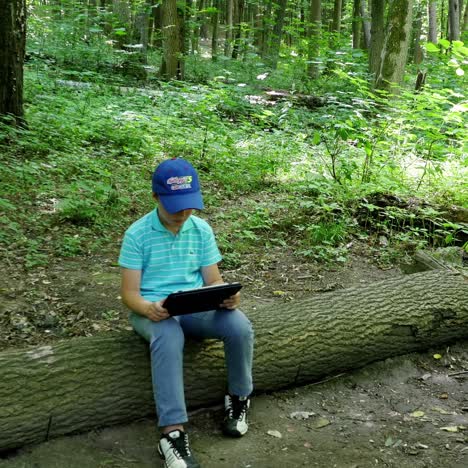 boy with tablet in the forest