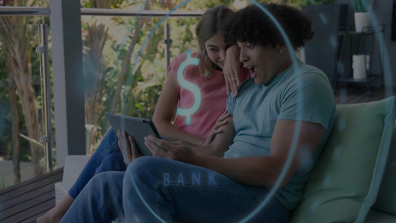 Casal sentado no sofá da varanda, homem tocando no tablet enquanto um HUD bancário se expande e revela o saldo da conta.