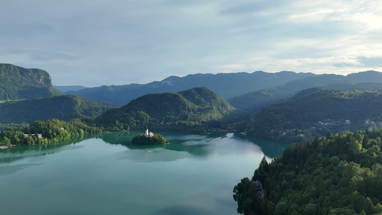 Ripresa aerea del lago di Bled e dell'isola con la chiesa circondata da foreste lussureggianti
