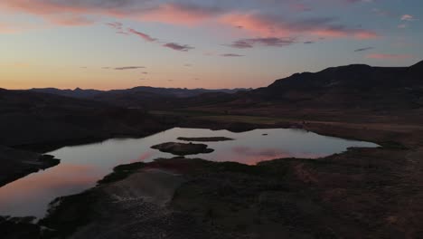 Vorwärtsbewegung-Aus-Der-Luft-In-Richtung-Teich-Bei-Sonnenuntergang-Mit-Reflexion-An-Den-Bemalten-Hügeln-In-Oregon