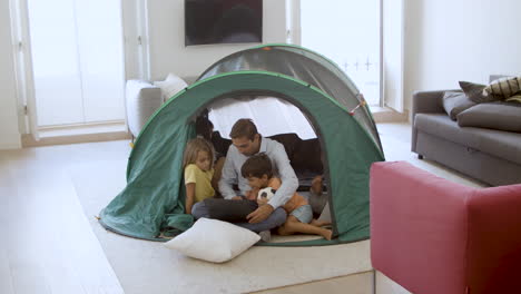 dad and kids watching movie on laptop