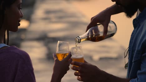 Paar-Gemischter-Abstammung-Beim-Weintrinken-Am-Strand-Bei-Sonnenuntergang-4k