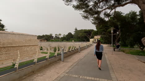 foto de uma turista caminhando por mdina, a antiga capital do estado de malta com edifícios antigos durante a noite