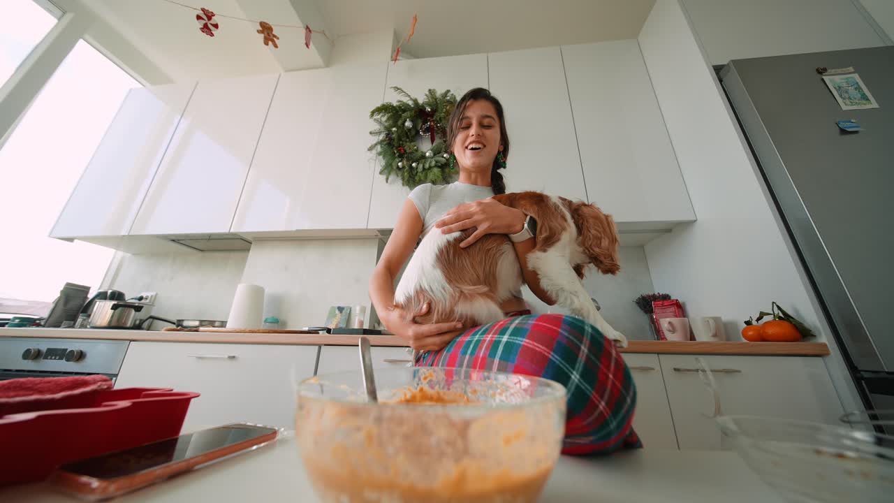 Woman and her dog are cooking at home during Christmas