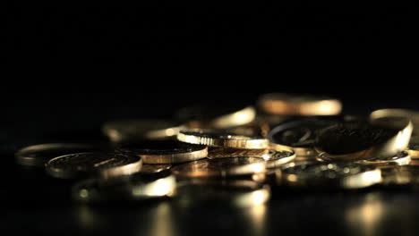 gold coins falling over dark background real footage not cg