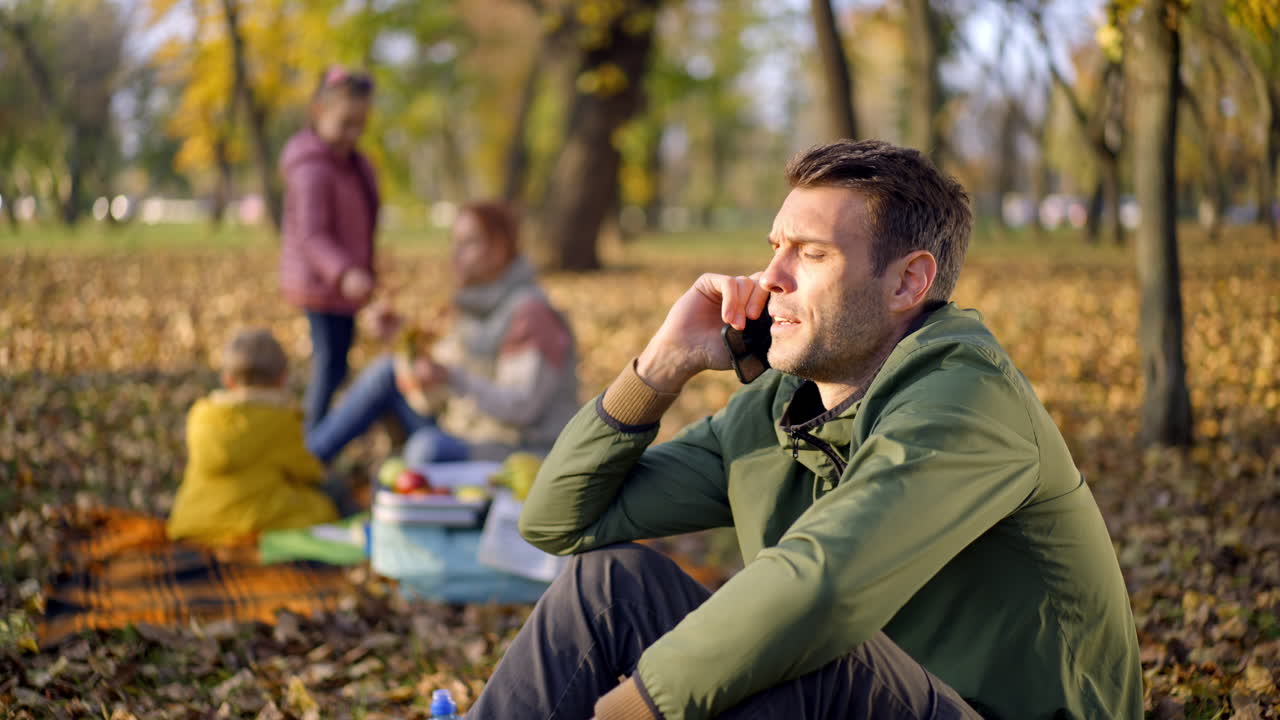 Family enjoying a picnic in the park on a fall day