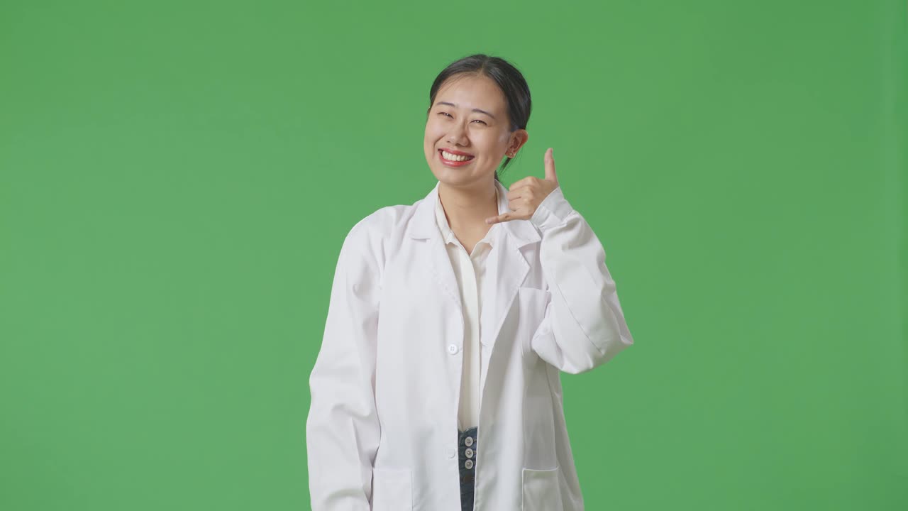 실험실 코트 를 입은 여자 가 몸짓 을 하고 있다