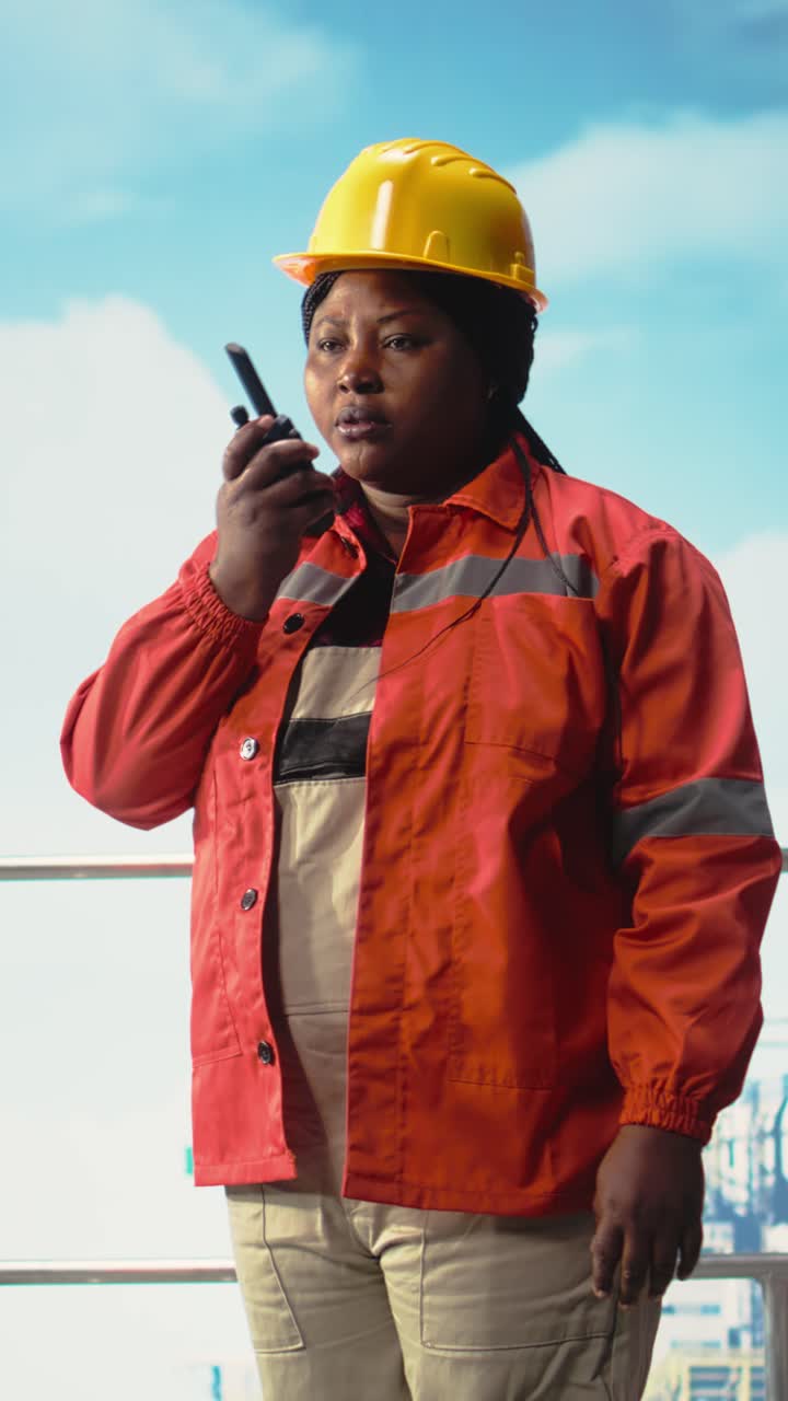 Vertical video Drilling rig specialist using walkie talkie, inspecting gear