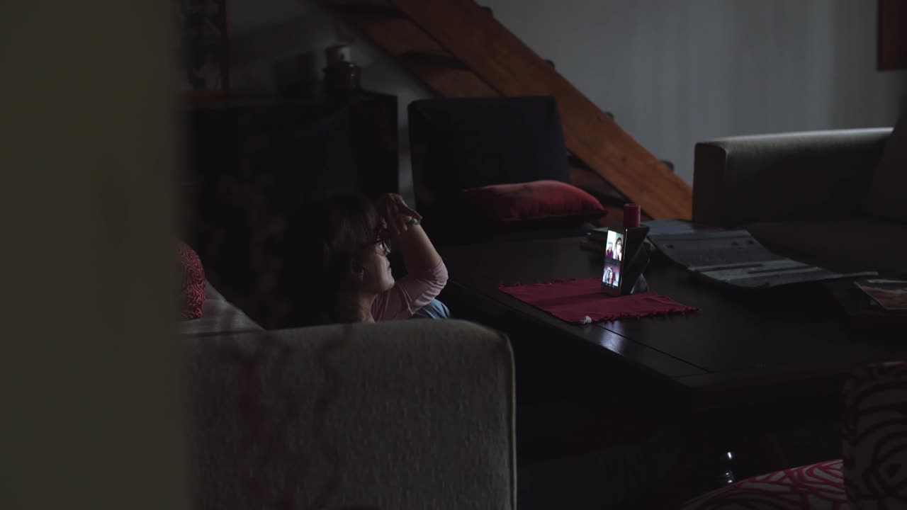 4K at 24fps - Woman having a video call on her cell phone in her living room - Home mood