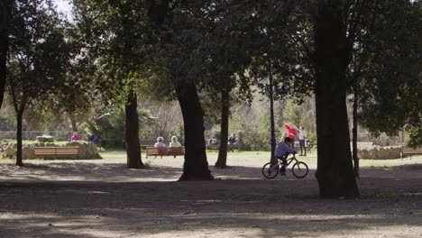 niño andando en bicicleta en park villa borghese