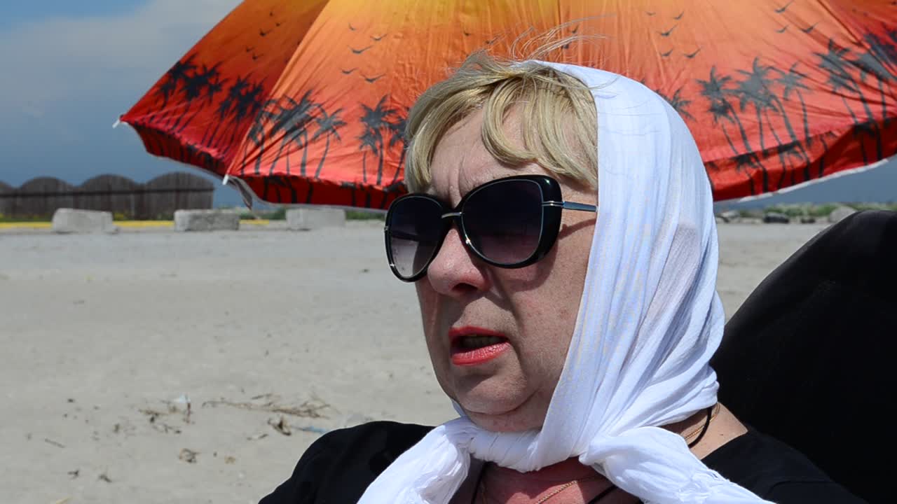 Kobieta i parasol. Odpoczynek na plaży.