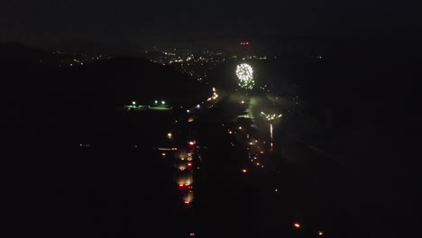 nighttime aerial view of fireworks over coastal city