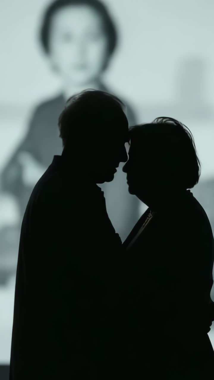 Vertical video: Light appearing showing seniors leaning in hall, with screen showing blurry faces