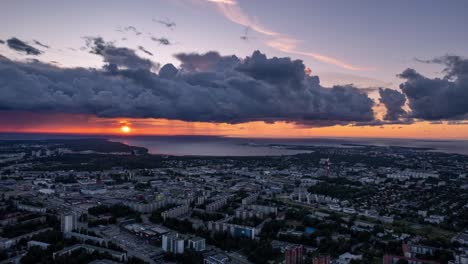 Hiperlapso-Aéreo-Del-Paisaje-Urbano-De-Tallin-En-Estonia,-Nubes-De-Puesta-De-Sol-Dramáticas,-De-Lado