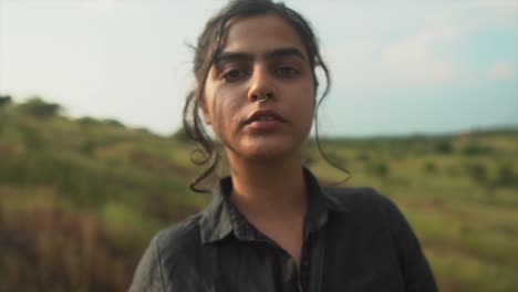 young adolescent woman in a black dress looking confident into the camera