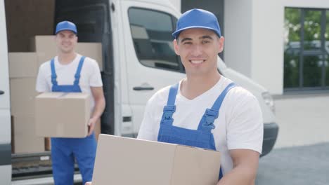 two young workers of removal company deliver boxes to a customer's home