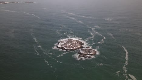 Una-Isla-Cubierta-De-Nieve-En-El-Atlántico-Con-Olas-Rompiendo