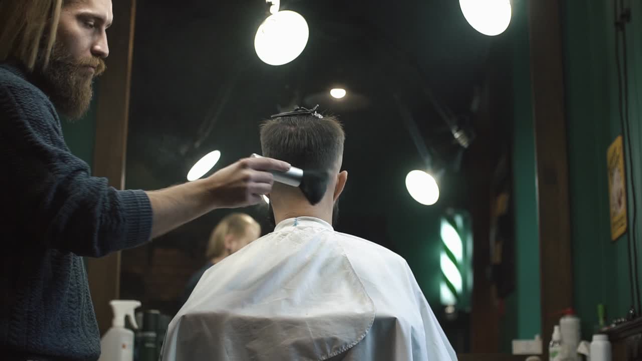 En barber klipper en kundes hår i en barbershop