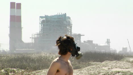 a man in a gas mask stands in front of a power plant