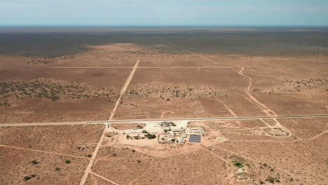 Aerial-view-over-a-building-with-solar-panels,-in-middle-of-desert,-South-Australian-outback---approaching,-drone-shot