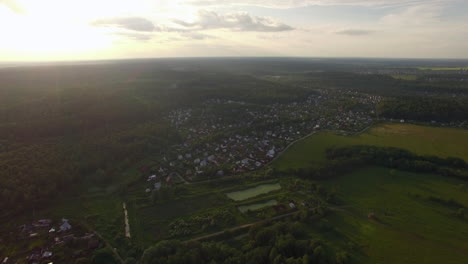 vista de las casas de campo del bosque contra el cielo azul con nubes en la puesta de sol en el verano de rusia