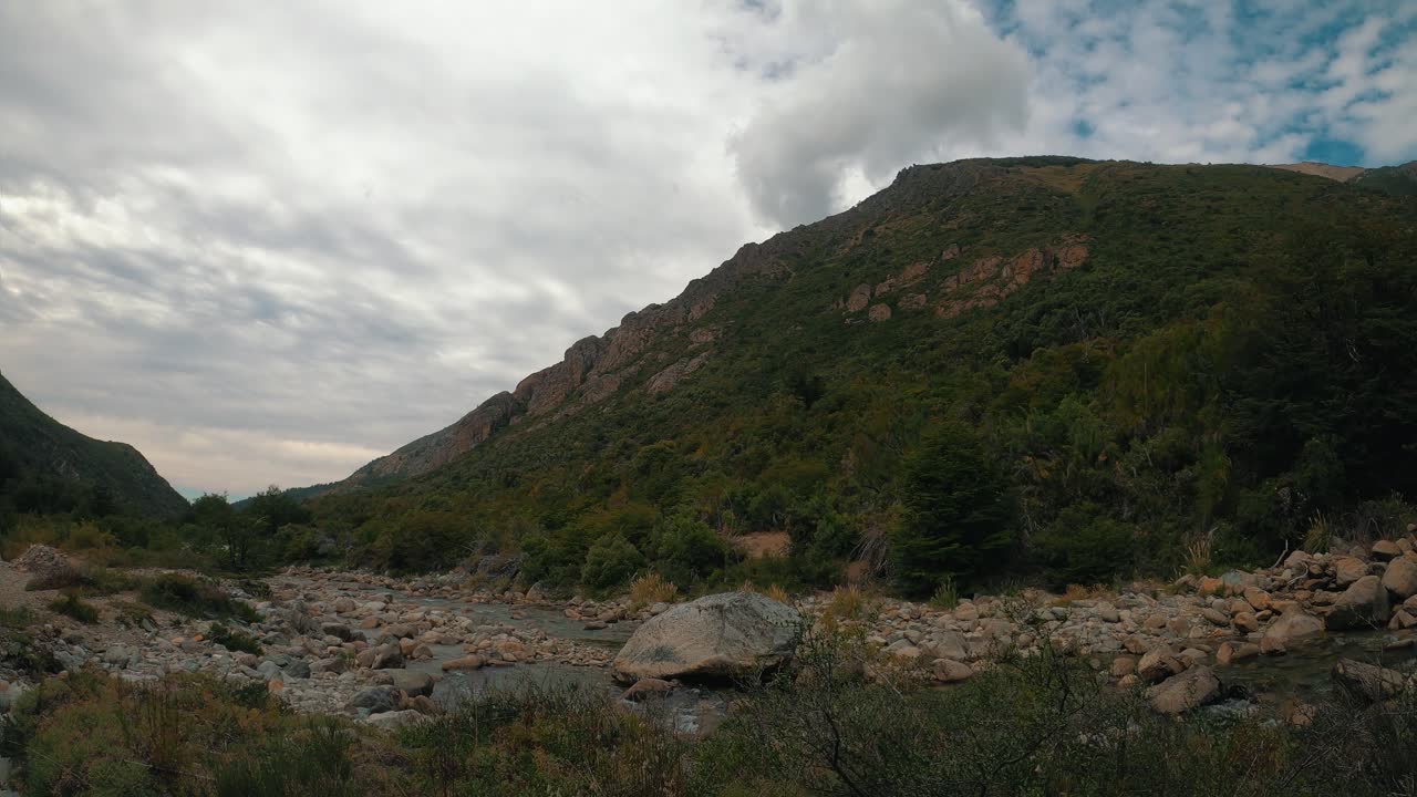 el agua fluye sobre el arroyo casa de piedra, bajo un cielo nublado, camino al refugio general san martin en san carlos de bariloche, argentina