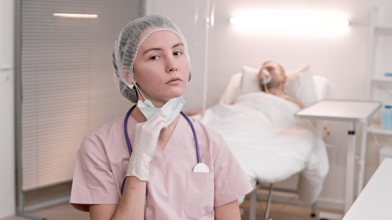 una joven doctora se quita la máscara.