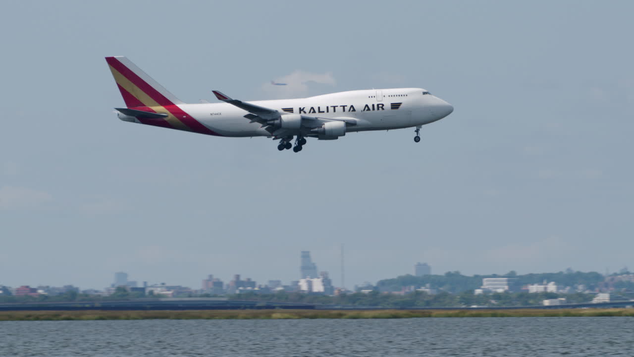 Camera Panning to Follow Kalitta Airlines Plane Passing Manhattan Skyline to Land at JFK Airport