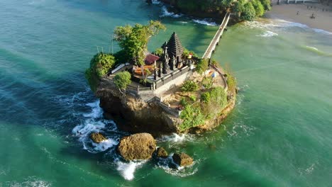 aerial orbiting view of balekambang hindu temple, java, indonesia on sunny day