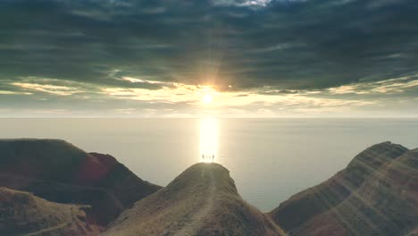 the four travelers standing on the mountain cliff against the seascape. hyperlapse