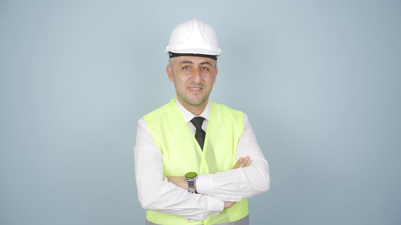 el ingeniero con un casco y sonriendo.