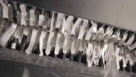 shredder cutting paper from below, two sheets, pan right to left