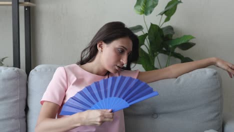 woman suffering from heatstroke cooling herself using fan