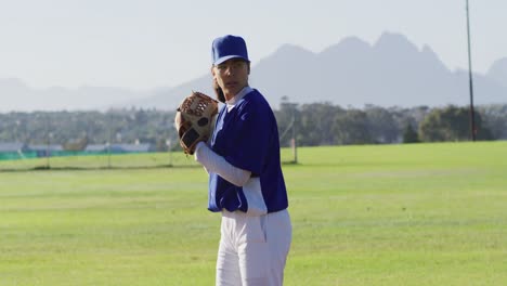 Caucasian-female-baseball-player-wearing-glasses-pitching-ball-on-baseball-field
