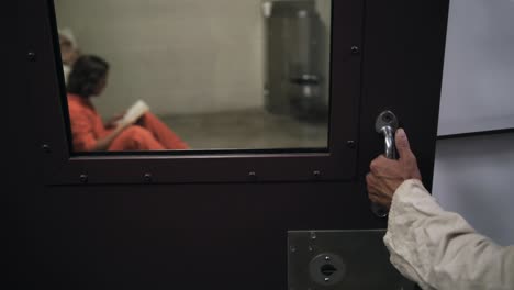 outside a prison cell as a prisoner inside reads his bible