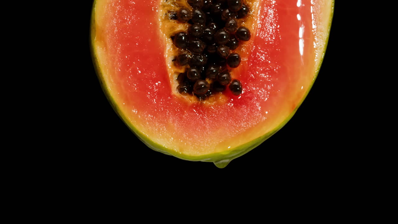Close-up of a papaya slice with dripping juice