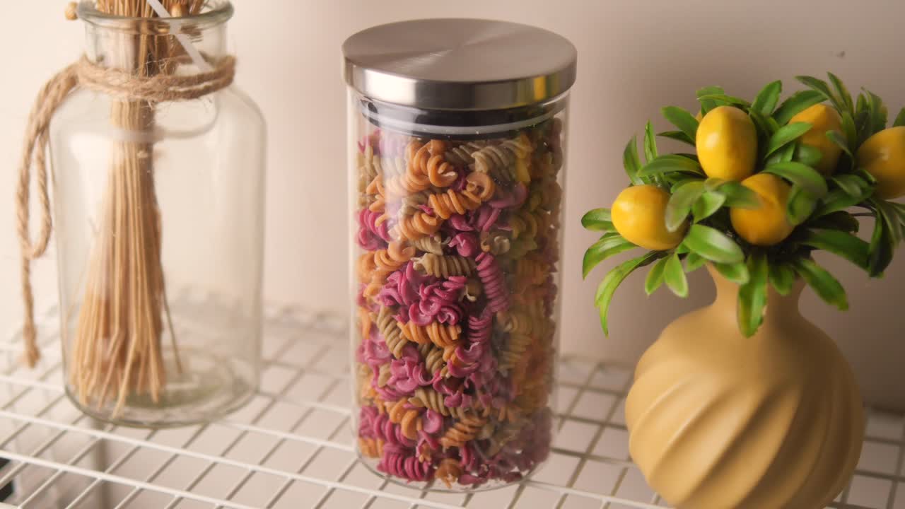 Massa fusilli colorida em pote de vidro com limões decorativos