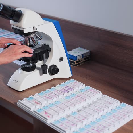 doctor during biochemical analysis. drop of samples between two microscope slides