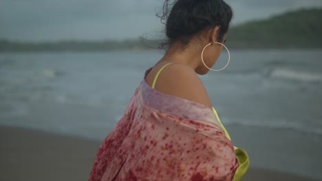 fotografía de cerca de una modelo con un vestido amarillo disfrutando de la brisa fría del océano en una playa de la india - rostro de una joven mujer bronceada con los ojos cerrados disfrutando de la brisa en la orilla del mar