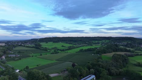 Farmland-of-crops-and-trees-on-green-slopes