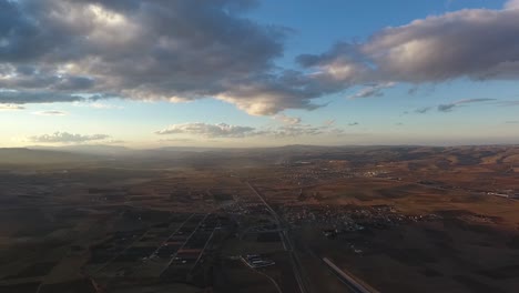 jet plane flights through clouds and fields below