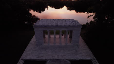 aerial view of a sunset over the roger williams park music temple and the lake in the background