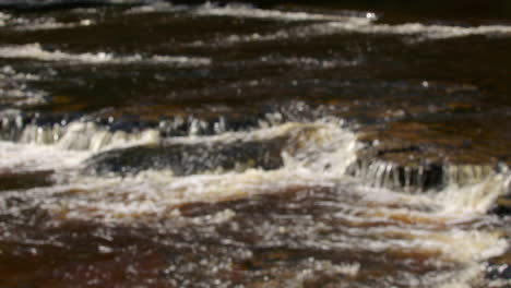 una toma fuera de foco del río ure pasando por encima de las rocas en aysgarth falls, yorkshire dales