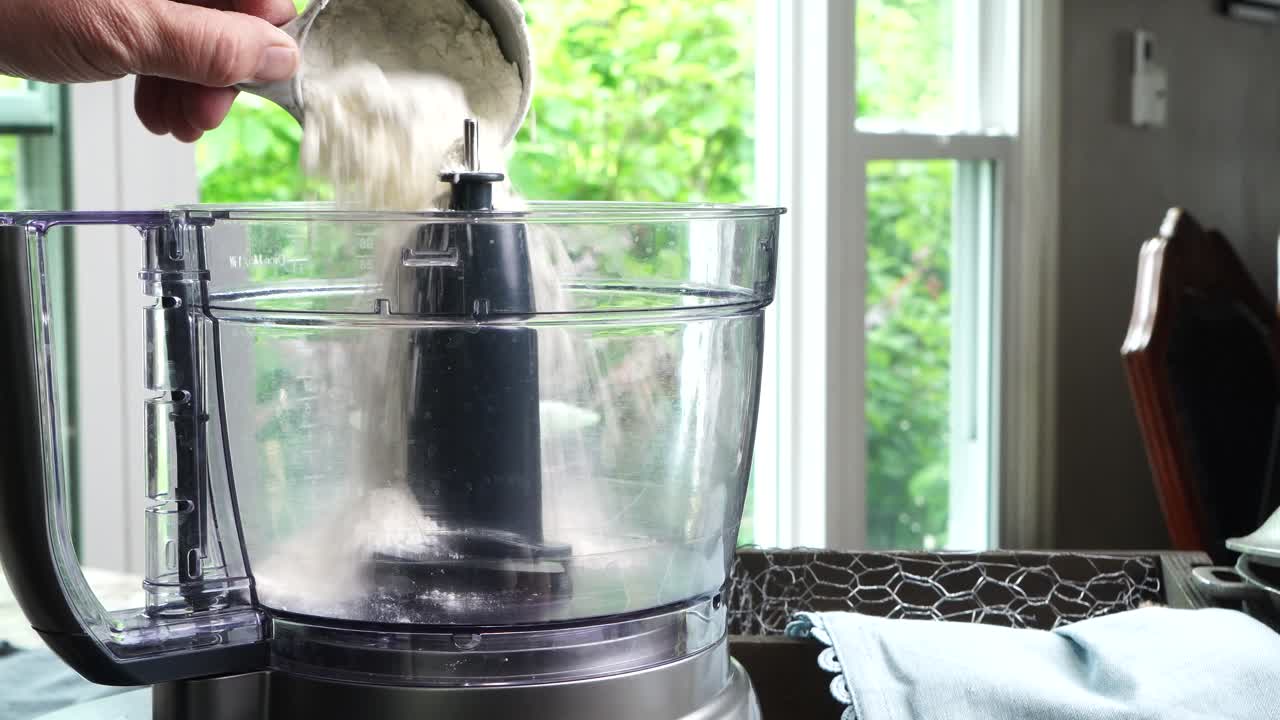 Using a food process or blender to make a dessert crust. Close up of mixing baking ingredients to make a dessert with a pie crust. Making brownies with a food processor for dessert.