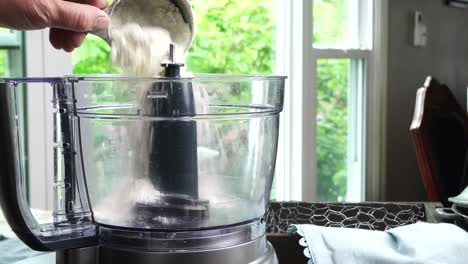 using a food process or blender to make a dessert crust. close up of mixing baking ingredients to make a dessert with a pie crust. making brownies with a food processor for dessert.