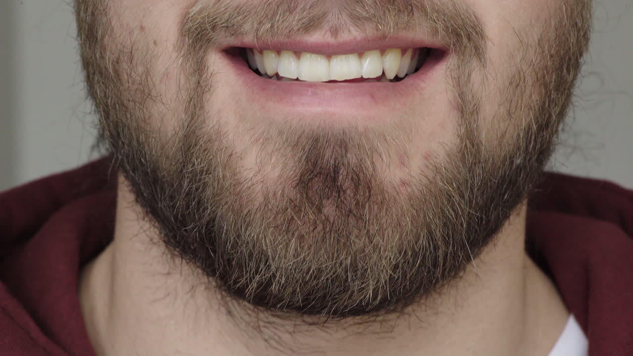 cerrar la boca de un joven sonriente hombre caucásico feliz con barba inferior de la cara