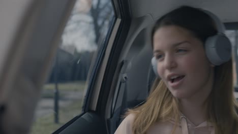 chica adolescente cantando junto a la música mientras conduce