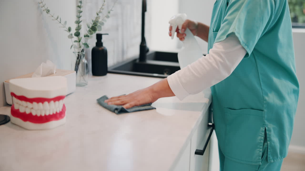 Dental Hygienist Cleaning and Disinfecting in a Dental Office