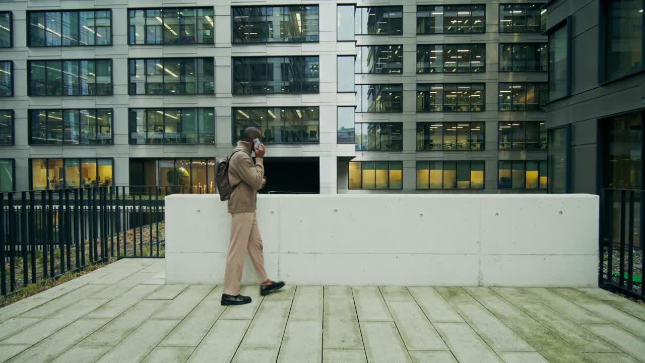 Businessman Walking and Talking on Phone in Cityscape