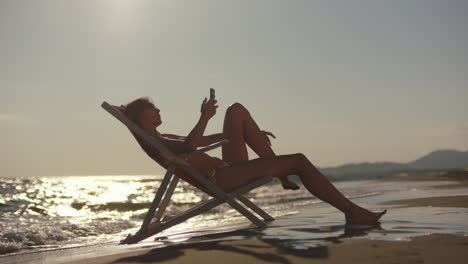 woman relaxing on beach chair at sunset